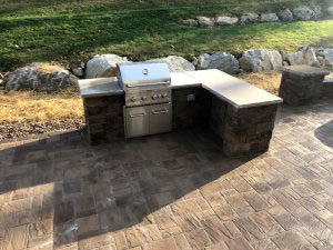 residential patio with an outdoor kitchen from Ryback Landscaping